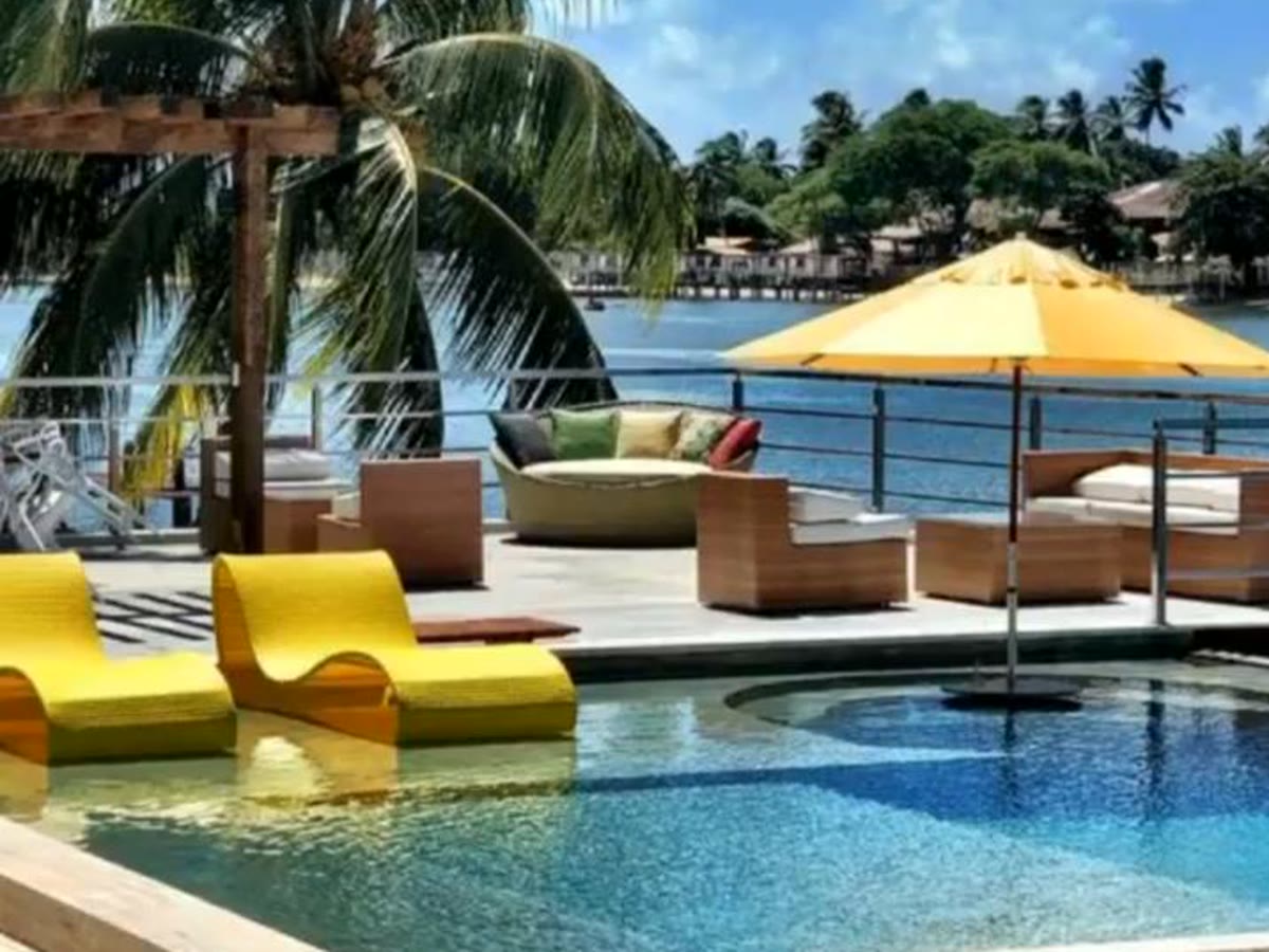 Piscina com deck e espreguiçadeiras amarelas à beira da água
